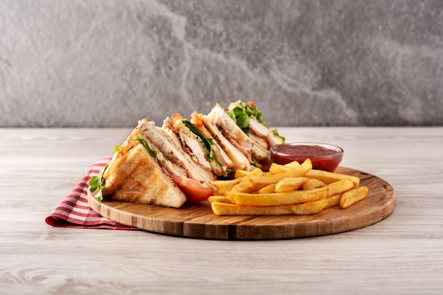 Premium Photo | Club sandwich and french fries on gray stone table