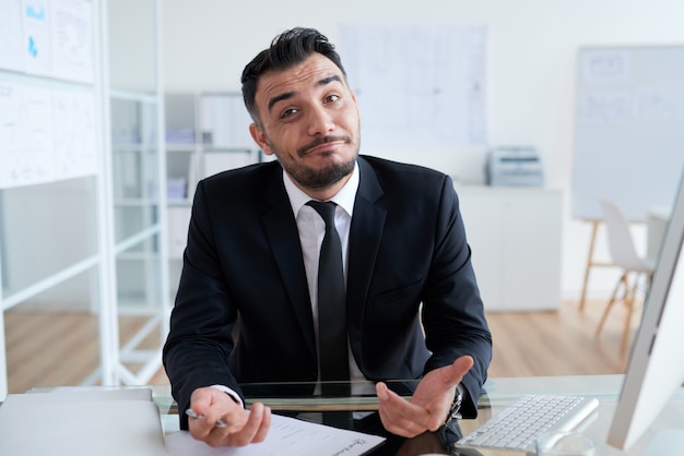 Free Photo | Clueless caucasian businessman sitting at desk in office ...