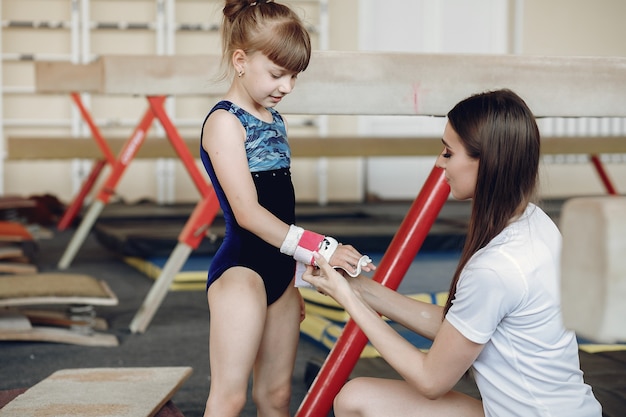 free-photo-coach-with-student-girls-gymnasts-performs-various