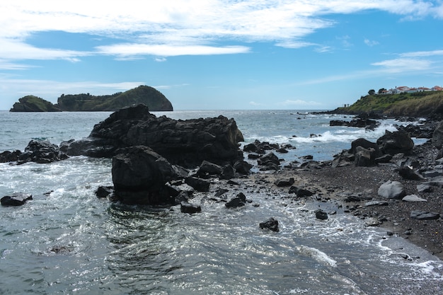 Coast rocks in azores. waves splashing on basalt rocks Premium Photo