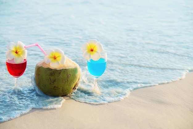 ココナッツとパイナップルのきれいな砂のビーチ フルーツと海のビーチで飲むカクテルグラス 無料の写真