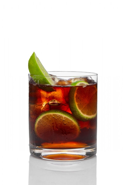 Premium Photo | Cocktail with rum and cola with ice and lime in ...