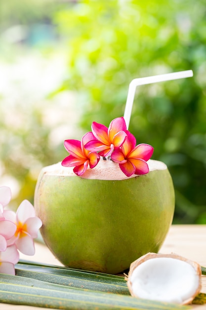 Premium Photo | Coconut drink with frangipani flower.