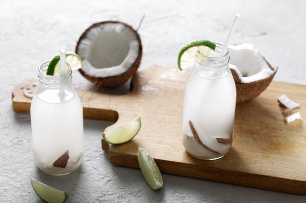 Coconut water in bottles on light background. healthy ...