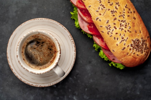 https://image.freepik.com/free-photo/coffee-and-a-sandwich-with-sausage-cheese-and-salad-on-a-stone-background-breakfast-concept_156140-3602.jpg