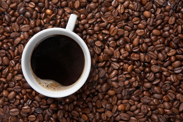 Premium Photo | Coffee cup on background of beans