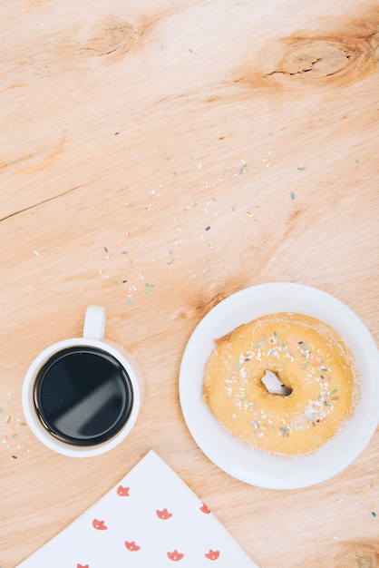 Download Free Photo Coffee Cup Donut With Sprinkles And Tissue Paper On Wooden Textured Backdrop