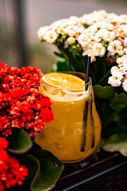 オレンジジュースとミントと氷をグラスに入れた冷たい柑橘系のカクテル バーでの色とりどりのアルコールカクテルドリンク プレミアム写真