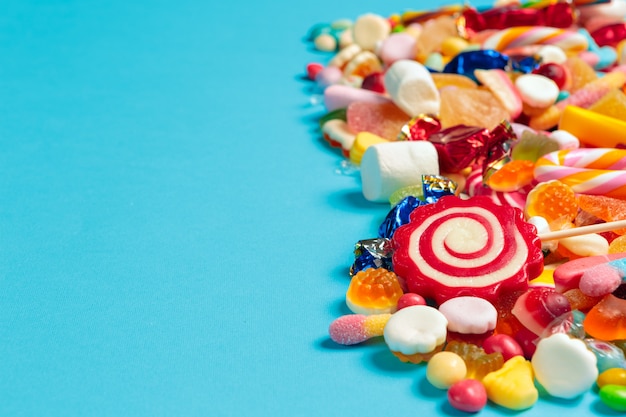 Premium Photo | Colored candies on blue background