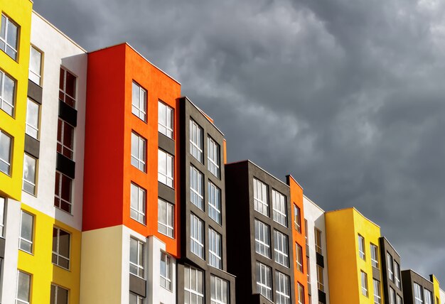 Colored facade of modern buildings against a stormy sky Premium Photo