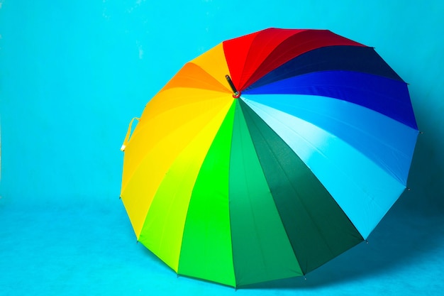 Premium Photo | Colored umbrella on a blue background . bright umbrella