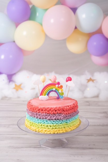 カラフルなバースデーケーキ パステルカラーの風船とレインボーケーキ 誕生日のお祝い プレミアム写真