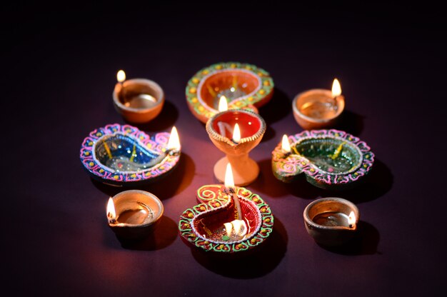 Premium Photo | Colorful clay diya (lantern) lamps lit during diwali ...