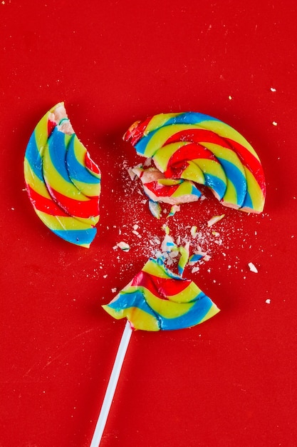 Free Photo | Colorful cracked lollipop on red surface.