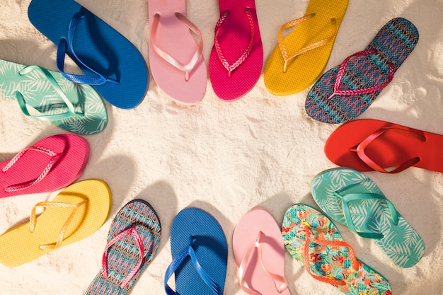 Premium Photo | Colorful flip-flops on sand