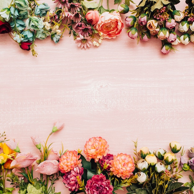 ピンクの木製の背景にカラフルな花 無料の写真