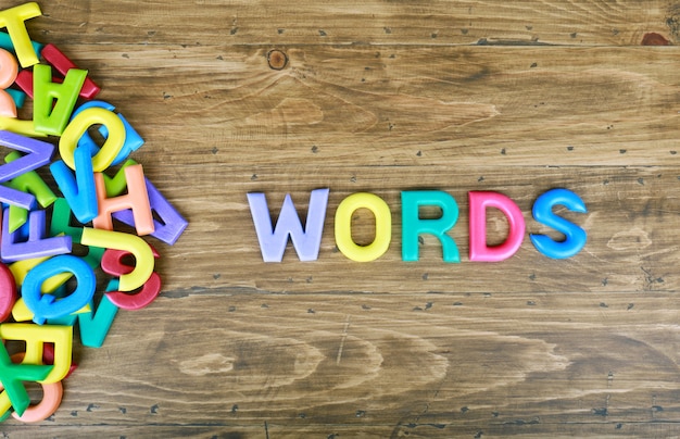 Premium Photo | Colorful letters words over wood background