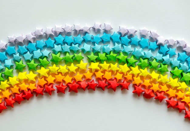 虹の背景を形成するカラフルな折り紙の星 無料の写真