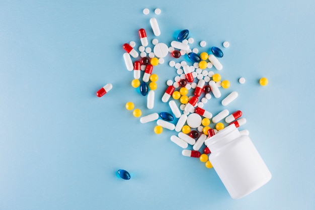 Colorful pills and plastic bottle Free Photo