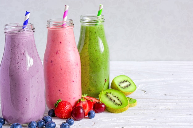 Premium Photo | Colorful smoothie drinks in bottles with fresh fruits ...