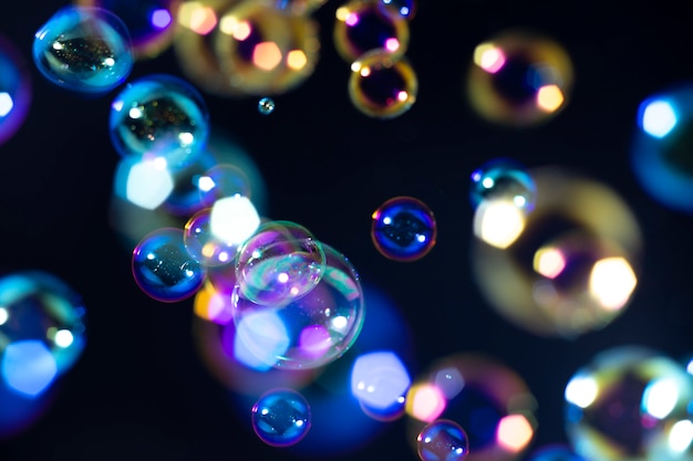 Premium Photo | Colorful soap bubbles float in the dark.