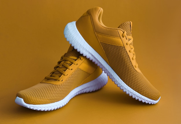 Colorful sport shoes on mustard color backround | Premium Photo