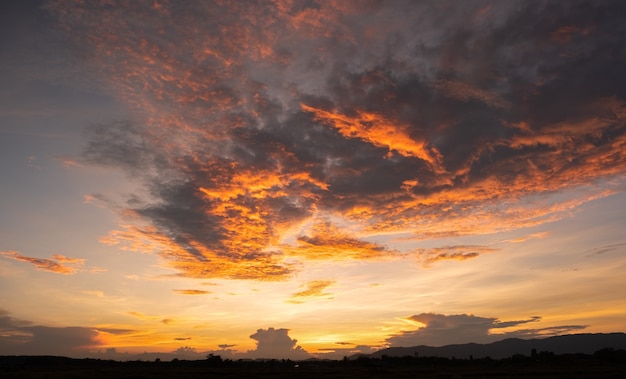 カラフルな夕焼けと日の出と雲 オレンジ色の自然 空にはたくさんの雲があります 雲に沈む夕日 空は夕暮れです プレミアム写真