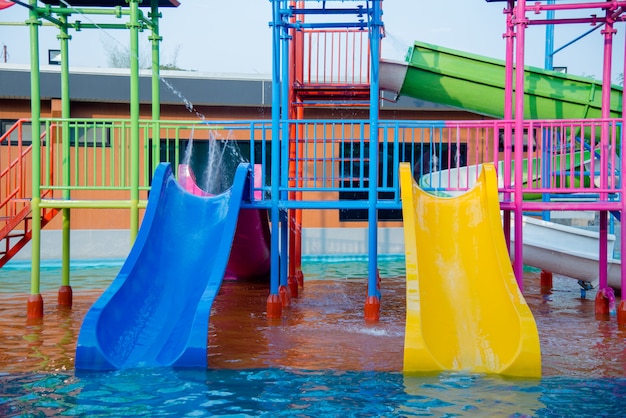 Colourful plastic slides in water park in the sunlight Free Photo