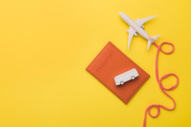 Composition of toy jet with airline passport and bus Free Photo