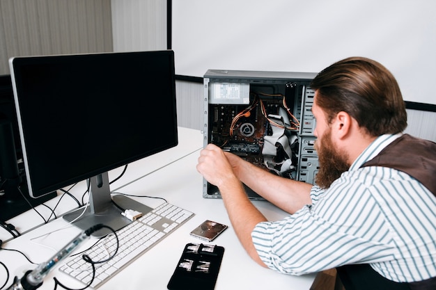 Premium Photo Computer Master Disassembling Cpu With Special Tools Repairman Workplace With Set Of Screws And Monitor On Table Pc Renovation Concept