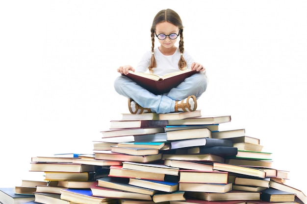 Concentrated girl surrounded by books Free Photo