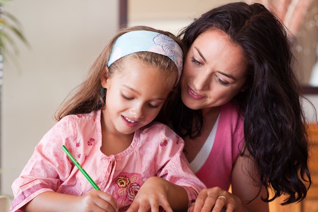 Premium Photo | Concentrated mother helping her daughter for homework