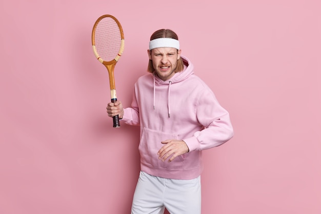 Concentrated tennis player holds racket ready to start game dressed in sportswear doesnt want to defeat prepares for sport competition. Free Photo