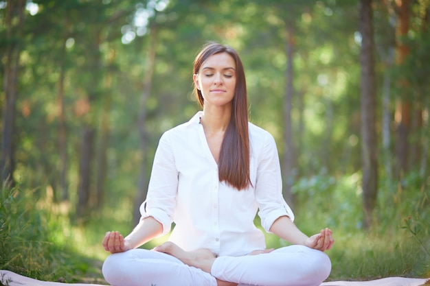 Concentrated woman meditating in nature Free Photo