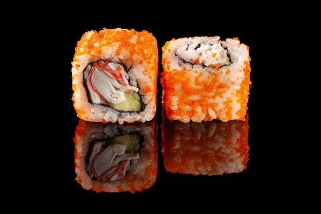 Concept of asian cuisine. two rolls of sushi with different fillings on a black background with the age for a japanese menu for a cafe, restaurant, sushi bar. Premium Photo