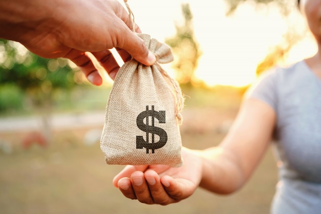 Premium Photo | Concept finance accounting. hand giving money bag for woman