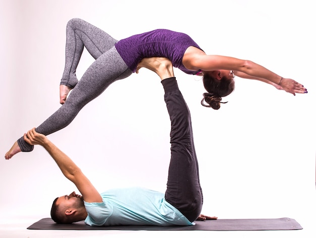 Concetto Di Esercizi Di Yoga Giovani Coppie In Buona Salute Nella Posizione Di Yoga Su Priorita Bassa Bianca Foto Gratis