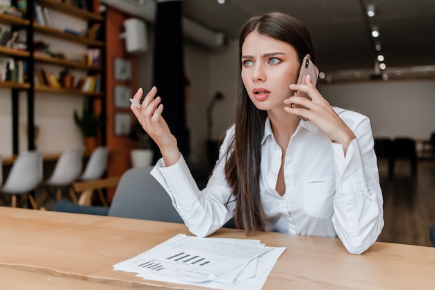 Premium Photo Concerned Businesswoman Talks On The Phone In The