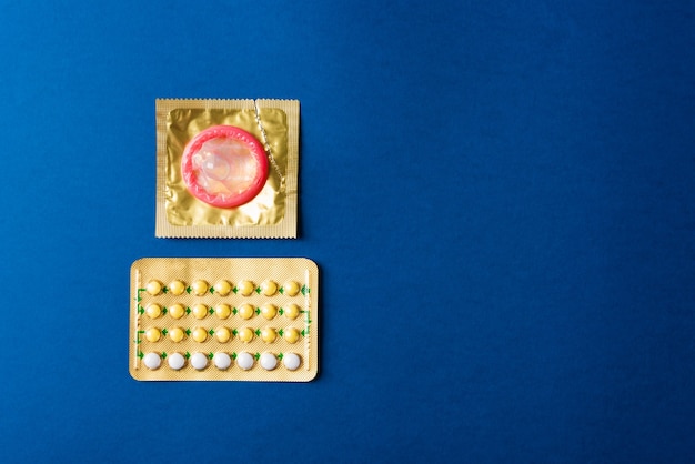 Premium Photo | Condom on wrapper pack and contraceptive pills blister ...