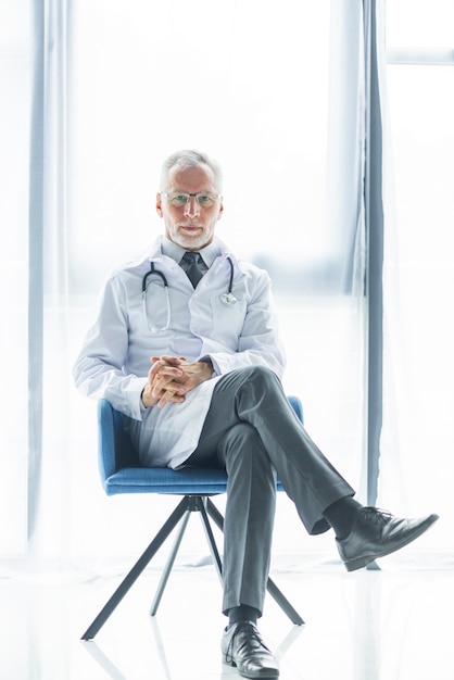 Free Photo | Confident doctor sitting on chair