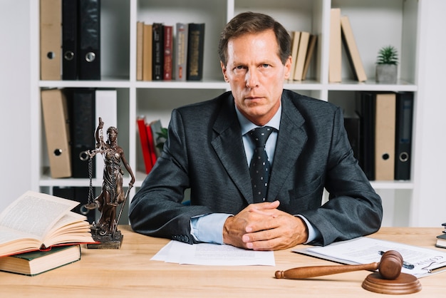 Confident mature lawyer sitting in courtroom Free Photo