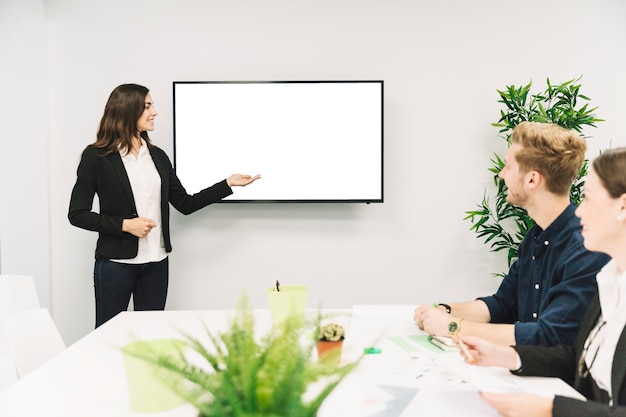 Confident smiling businesswoman giving presentation to her partners Free Photo