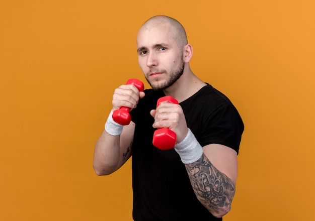 Free Photo | Confident young sporty man wearing wristband holding ...