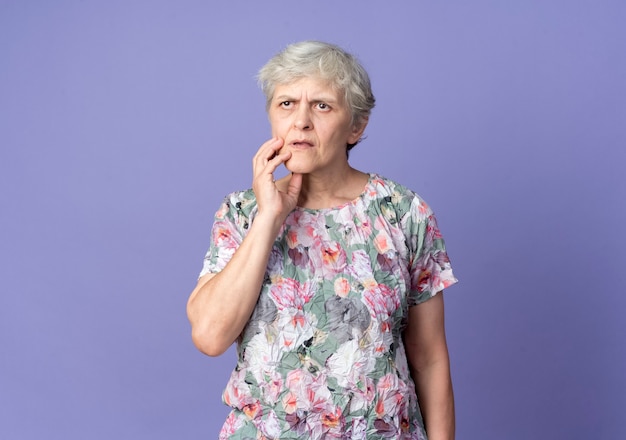 Free Photo | Confused elderly woman puts hand on chin isolated on ...