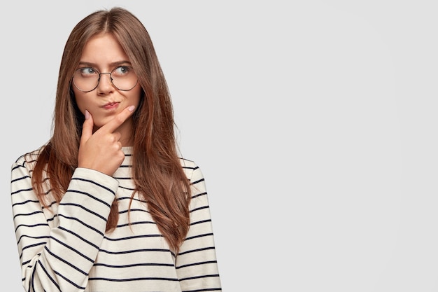 girl with glasses wearing stripes thinking