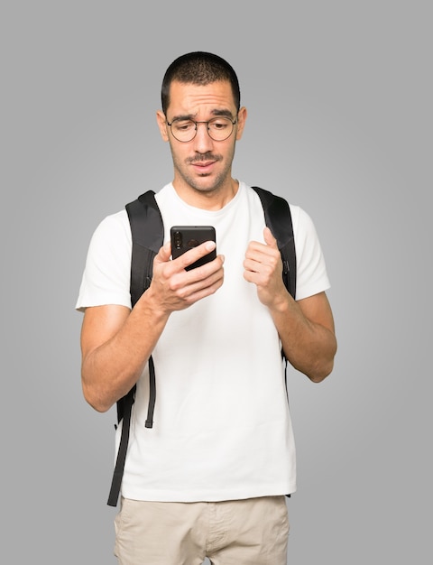 Premium Photo | Confused student using a mobile phone