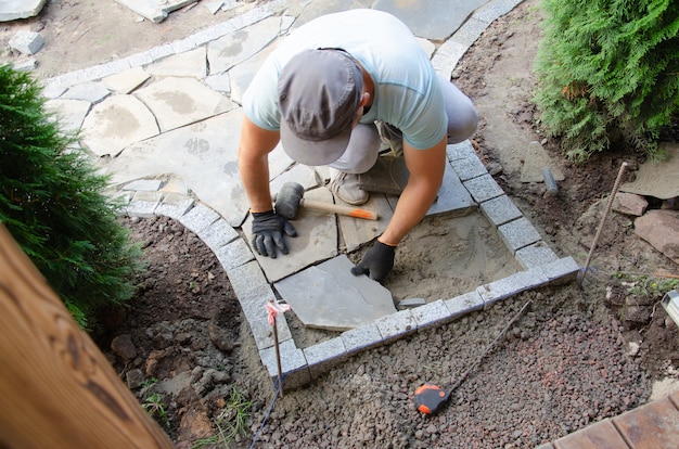 Premium Photo | Construction of pavement near the house. bricklayer places  concrete paving stone blocks for building up a sidewalk pavement