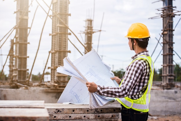 Construction worker checking blueprints on site | Premium Photo