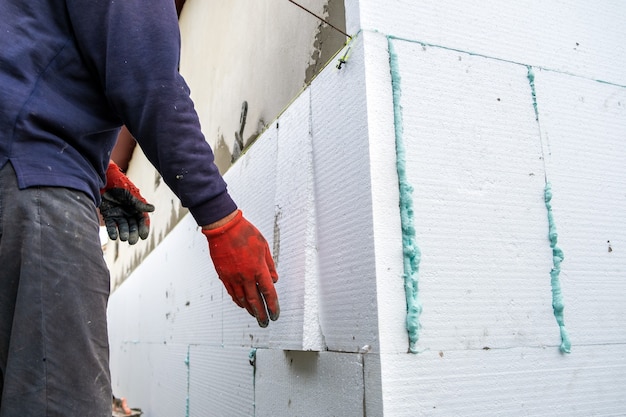 Premium Photo | Construction worker installing styrofoam insulation ...