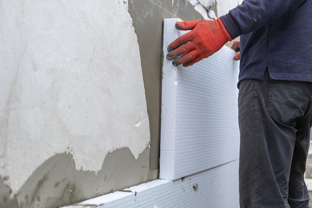 Premium Photo | Construction worker installing styrofoam insulation ...